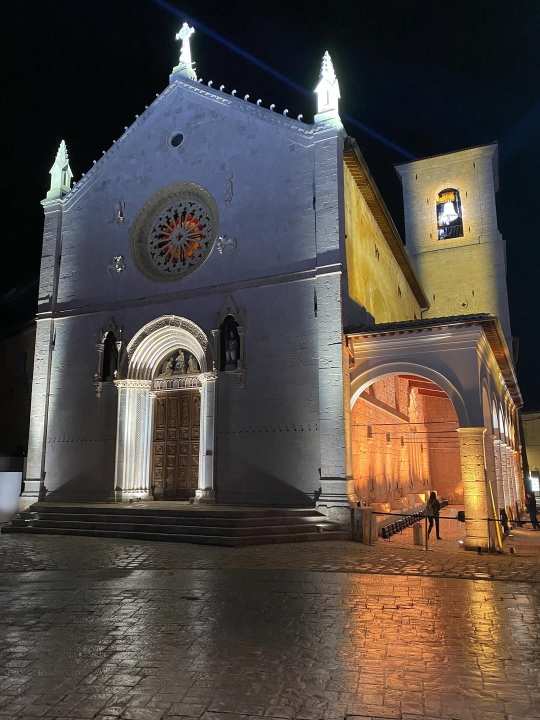 La facciata e il campanile della Basilica di San Benedetto a Norcia illuminati di notte